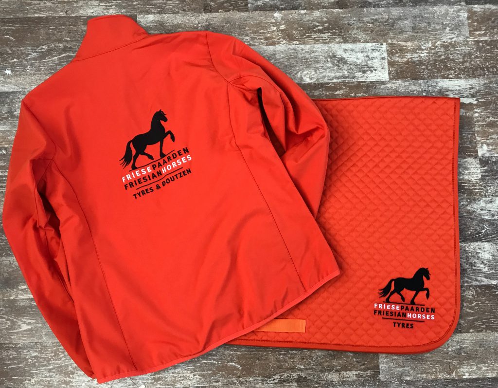 Zadeldek en bijpassende softshell met het logo van Friese Paarden/Friesian Horses logo, door ZijHaven3, borduurstudio Lemmer