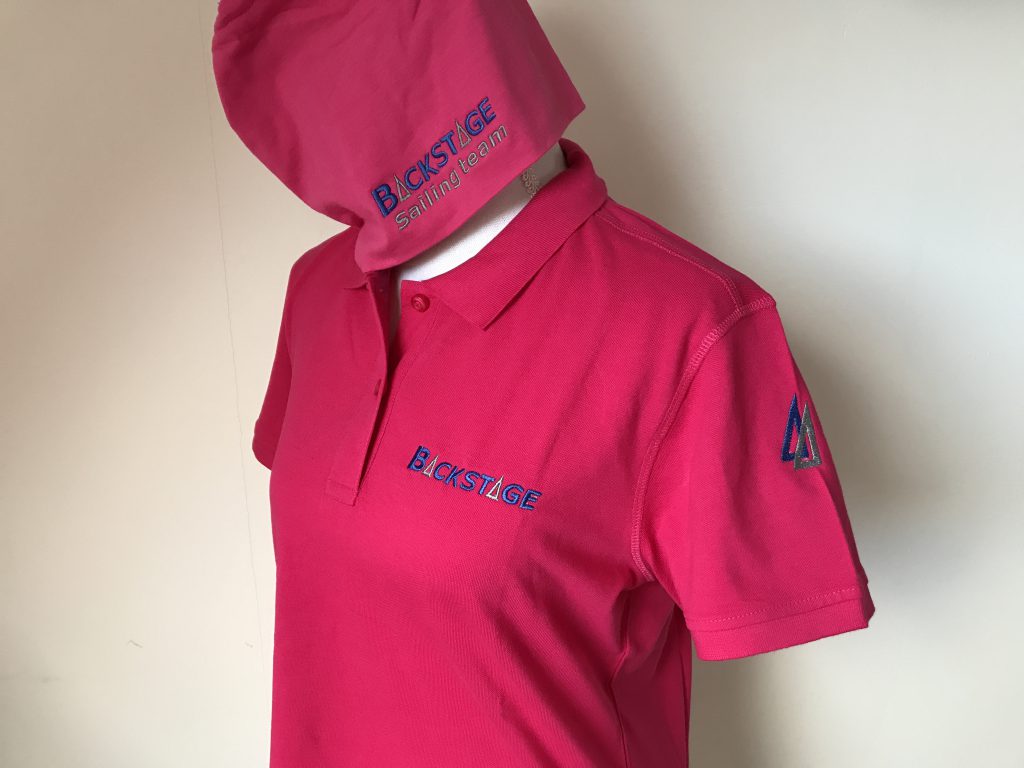 Zeilsport, polo dames en beanie, roze, met bootnaam en mouwembleem, door ZijHaven3 borduurstudio Lemmer